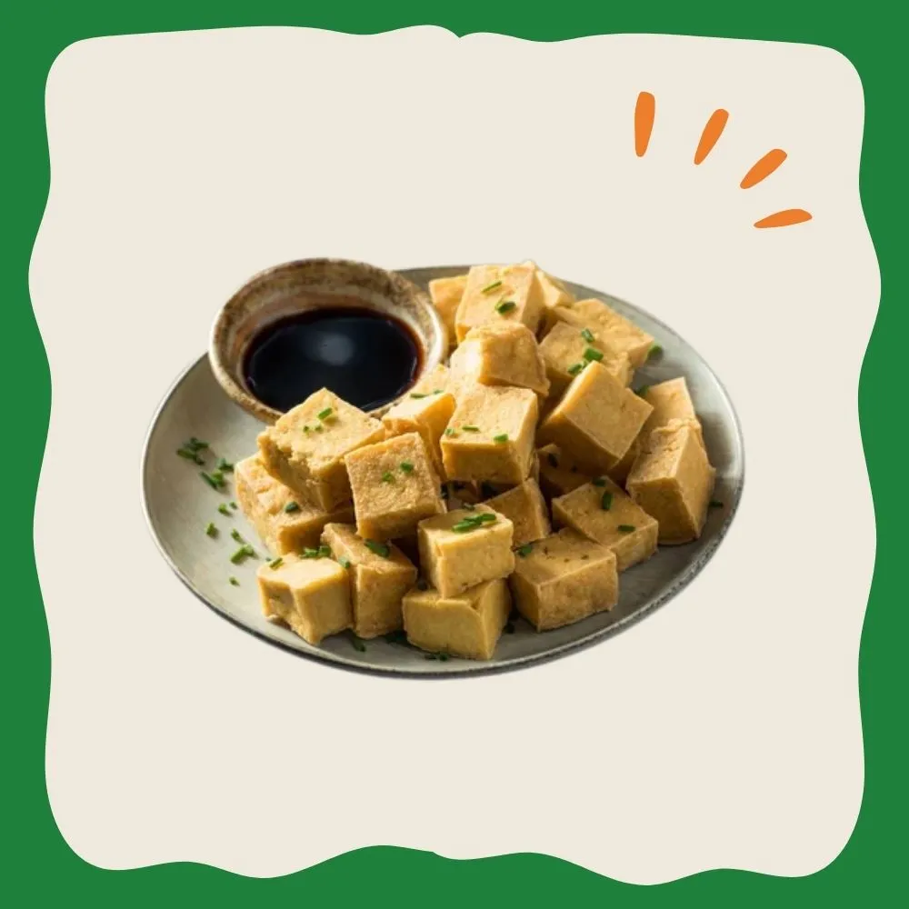 Fotografía de varios cubos de tofu sazonados con condimentos y acompañados de salsa de soja